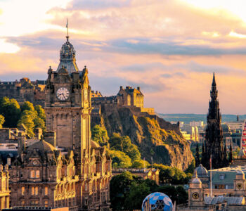Edinburgh skyline at sunset featuring the Balmoral Hotel clock tower, Edinburgh Castle, and the Scott Monument.
