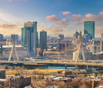 Boston skyline and Zakim Bridge viewed at sunset above the Charles River in downtown Massachusetts.