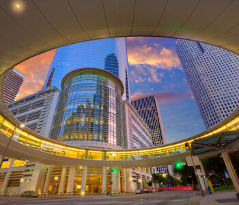 Modern skyscrapers and elevated architecture in downtown Houston, Texas at sunset.