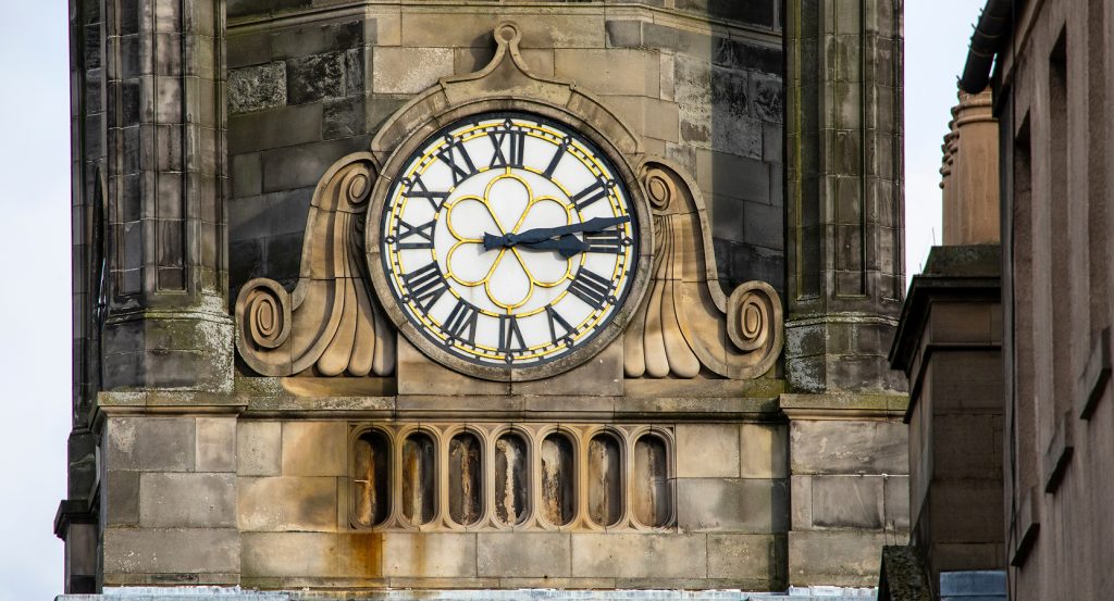 Illuminated Tron Kirk Clock glowing at night in Edinburgh