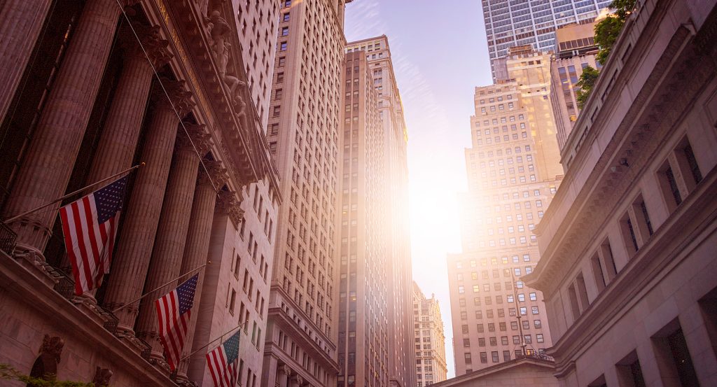 unlight shining on skyscrapers and NYSE on Wall Street