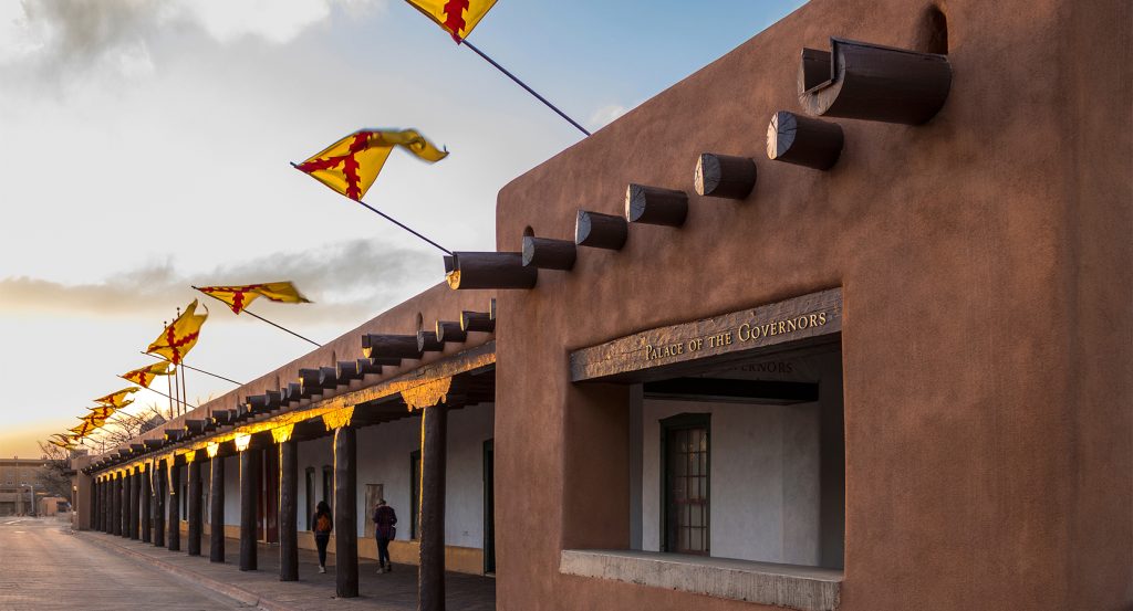 Native artisans selling jewelry beneath the Palace of the Governors portal
