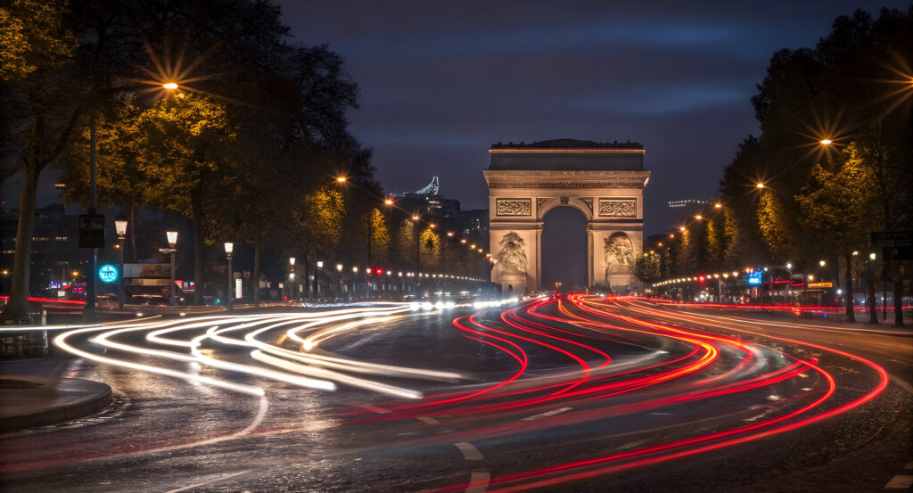 Arc de Triomphe at the end of Champs Élysées with vibrant city lights