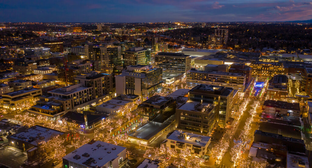 Shops and restaurants along Cherry Creek with festive lights