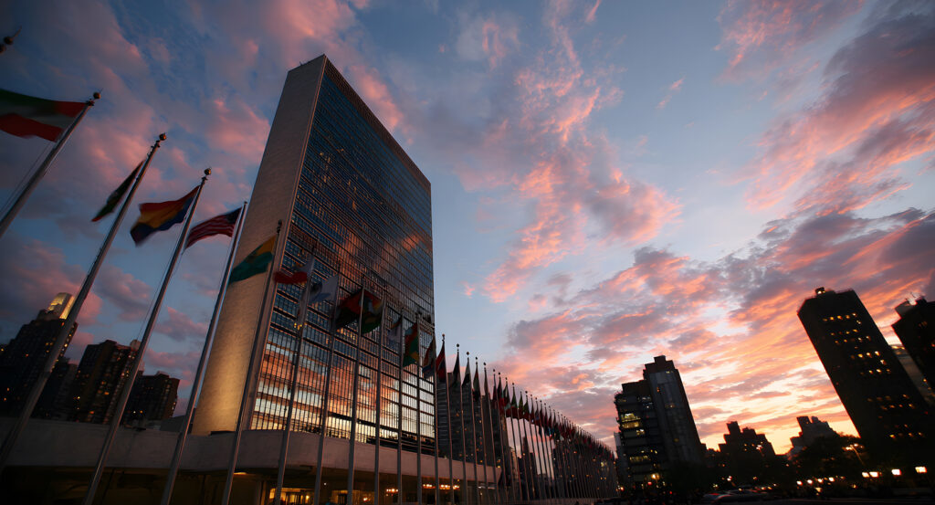 Exterior of the UN building with rows of flags and dramatic sky