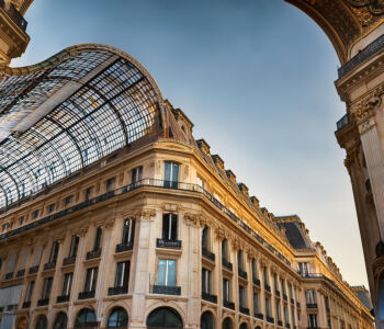 Glass-domed roof of Galeries Lafayette arching over ornate Haussmann-style architecture in Paris.
