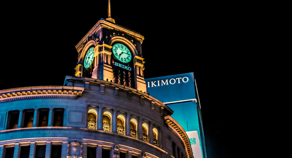 Neon-lit shopping street in Ginza Tokyo with luxury stores