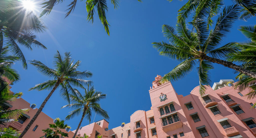 Exterior view of the Royal Hawaiian Hotel under blue Honolulu skies
