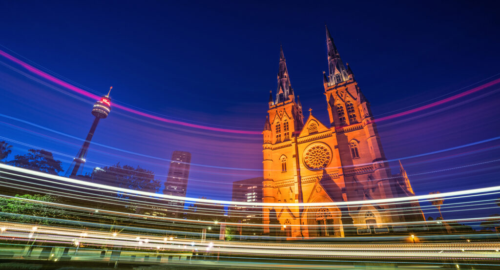 Gothic spires of St Mary's Cathedral illuminated against evening sky in Sydney