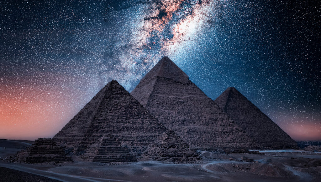 Ancient Pyramids of Giza glowing beneath a starry desert sky