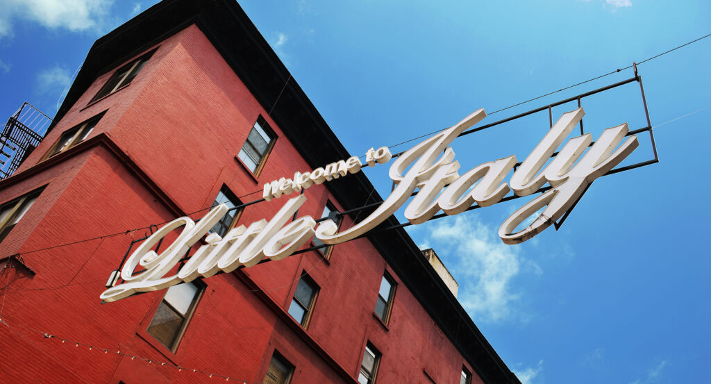 Red brick building with Little Italy sign on a sunny day