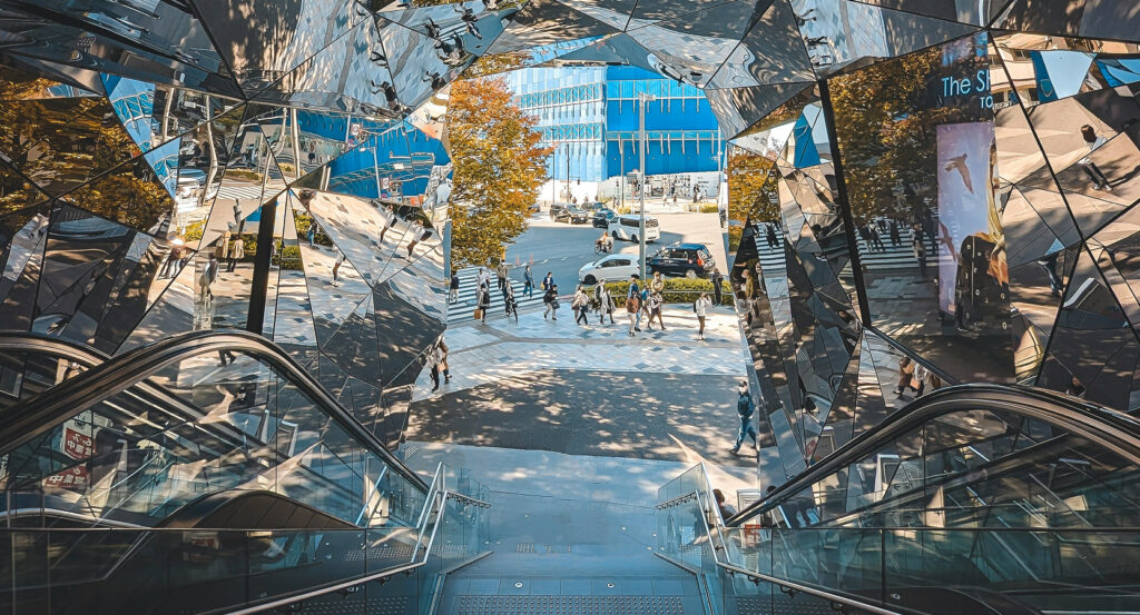 Tree-lined avenue of Omotesando in Tokyo with modern architecture and shoppers