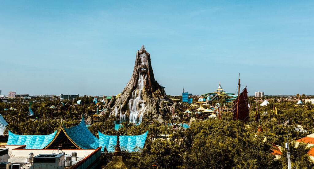 Waterfall cascading down the central volcano surrounded by tropical foliage at Volcano Bay in Orlando
