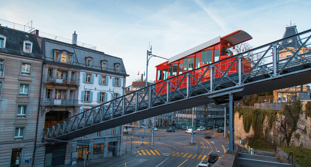 Polybahn funicular car on inclined track with Zurich street scene below