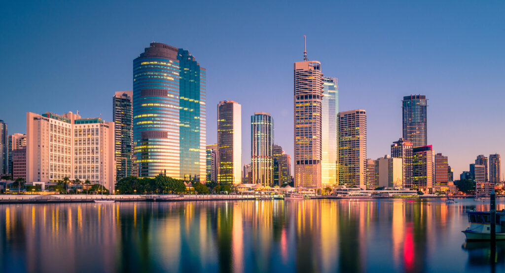 Waterfront Place glowing with golden light beside the Brisbane River