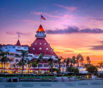 Sunset over the historic red-roofed Victorian Hotel del Coronado on Coronado Island in San Diego.