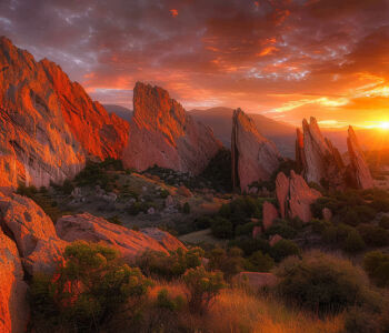 Garden of the Gods rock formations glowing at sunset under dramatic orange and purple clouds.
