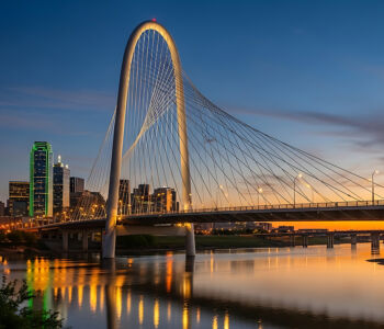 Margaret Hunt Hill Bridge glowing over the Dallas skyline at sunset