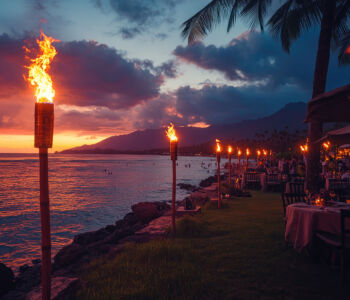 Tiki torches lighting a seaside restaurant at sunset on the Big Island of Hawaii