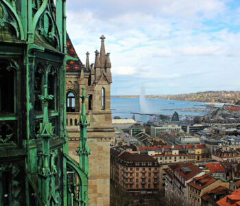 View of Geneva from St. Pierre’s Cathedral tower overlooking rooftops and the Jet d’Eau.