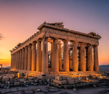 Parthenon at golden hour with warm sunlight illuminating its ancient marble columns atop the Acropolis in Athens.